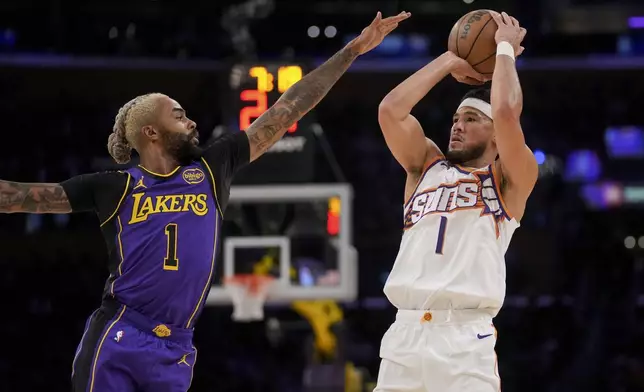 Phoenix Suns guard Devin Booker (1) shoots over Los Angeles Lakers guard D'Angelo Russell (1) during the first half of an NBA basketball game against the in Los Angeles, Friday, Oct. 25, 2024. (AP Photo/Eric Thayer)