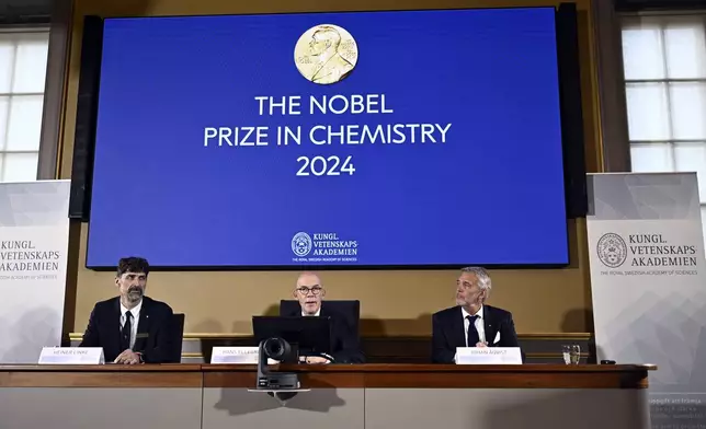 Johan Åqvist, member of the Nobel Committee for Chemistry, Hans Ellegren, Permanent Secretary and Heiner Linke, Chairman of the Nobel Committee for Chemistry award this years Nobel Prize in Chemistry to David Baker, Demis Hassabis, and John Jumper at the Royal Swedish Academy of Sciences, in Stockholm, Sweden, Wednesday, Oct. 9, 2024. (Christine Olsson/TT News Agency via AP)