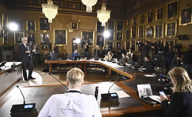 Journalists listen when Jan Teorell of the Nobel assembly announces the Nobel memorial prize in economics winners during a press meeting at the Royal Swedish Academy of Sciences in Stockholm, Sweden, Monday Oct. 14, 2024. (Christine Olsson/TT News Agency via AP)