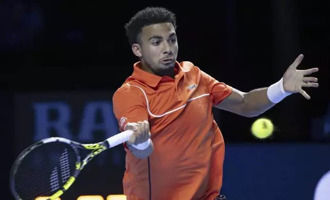 France's Arthur Fils returns a ball to Greece's Stefanos Tsitsipas during their quarter final match of the Swiss Indoors Basel tennis tournament, at the St. Jakobshalle, in Basel, Switzerland, Friday, Oct. 25, 2024. (Georgios Kefalas/Keystone via AP)