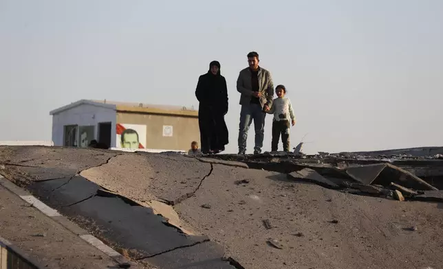 Syrian citizens observe a bridge that links to Lebanon which was destroyed on Oct. 24 by an Israeli airstrike, in Qusair, Syria, Sunday, Oct. 27, 2024. (AP Photo/Omar Sanadiki)