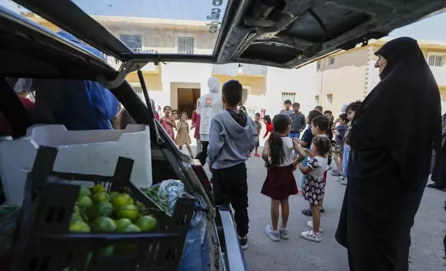 Displaced families fleeing the war in Lebanon, gather at the Herjalleh shelter center in Damascus countryside, Syria, Tuesday, Oct. 15, 2024. (AP Photo/Omar Sanadiki)