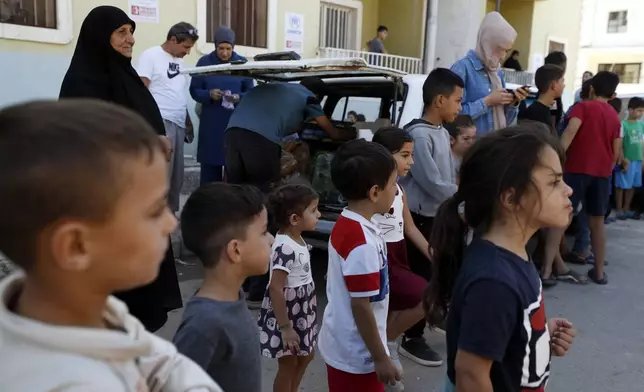 Displaced families fleeing the war in Lebanon, gather at the Herjalleh shelter center in Damascus countryside, Syria, Tuesday, Oct. 15, 2024. (AP Photo/Omar Sanadiki)