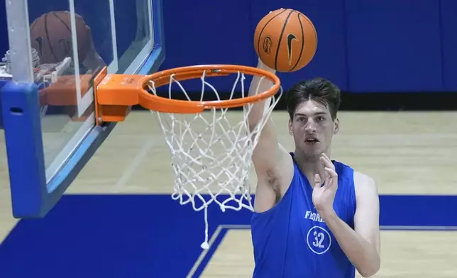 Olivier Rioux, a 7-foot-9 NCAA college basketball player at Florida, dunks the ball as he practices with the team, Friday, Oct. 18, 2024, in Gainesville, Fla. (AP Photo/John Raoux)