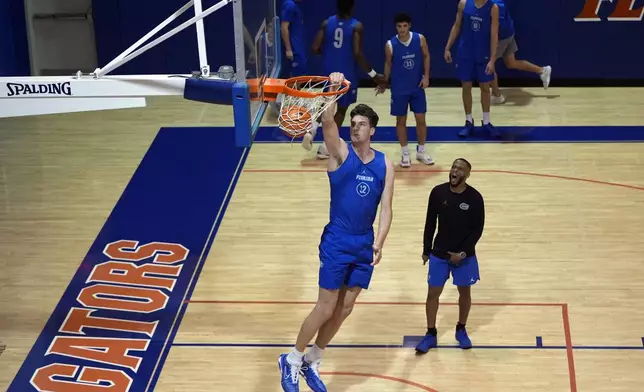 Olivier Rioux, 7-foot-9 NCAA college basketball player at Florida, dunks the ball as he practices with the team, Friday, Oct. 18, 2024, in Gainesville, Fla. (AP Photo/John Raoux)