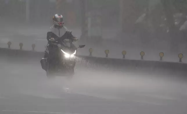 A man rides motorbike as Typhoon Kong-rey approaches in Taipei, Taiwan, Thursday, Oct. 31, 2024. (AP Photo/Chiang Ying-ying)