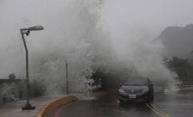 A car moves along the shore in Kaohsiung, Southern Taiwan, Wednesday, Oct. 2, 2024, as Typhoon Krathon is expected to hit the area. (AP Photo/Chiang Ying-ying)