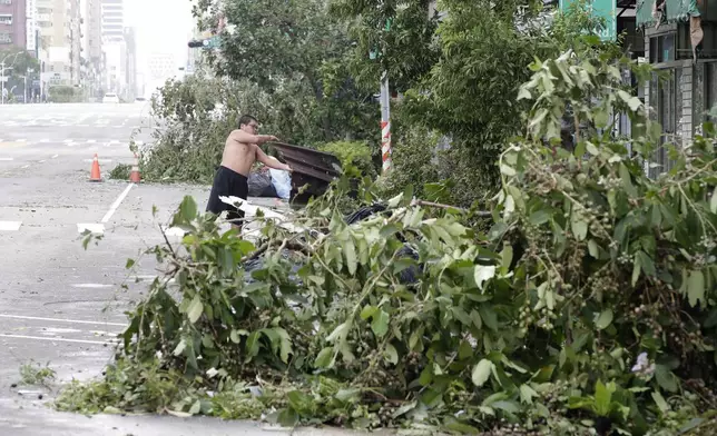 A man clears debris in the aftermath of Typhoon Krathon in Kaohsiung, southern Taiwan, Friday, Oct. 4, 2024. (AP Photo/Chiang Ying-ying)