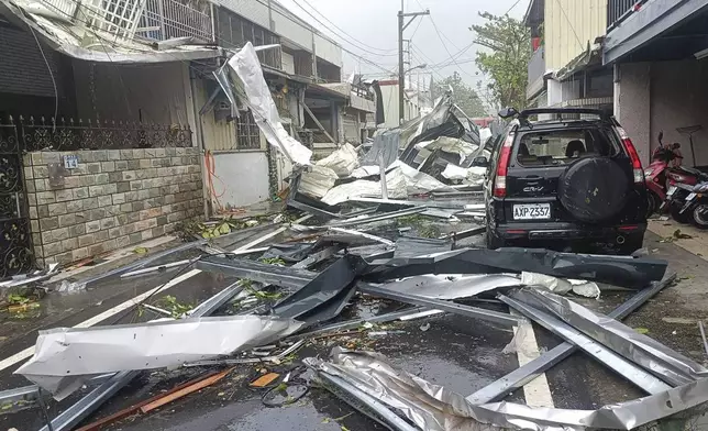 In this photo released by Hualien County Fire Department, a blown roof destroyed by the wind of Typhoon Kong-rey, lay across a road in Hualien County, eastern Taiwan, Thursday, Oct. 31, 2024. (Hualien County Fire Department via AP)