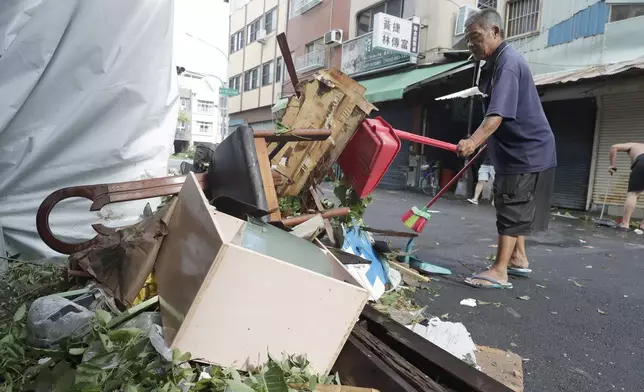 A man clears debris in the aftermath of Typhoon Krathon in Kaohsiung, southern Taiwan, Friday, Oct. 4, 2024. (AP Photo/Chiang Ying-ying)