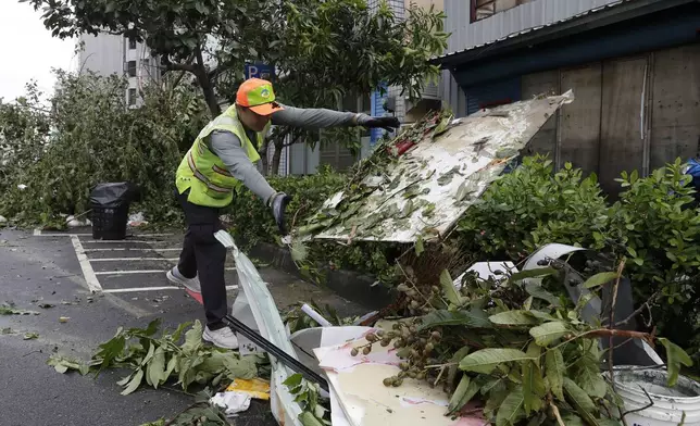 A sanitation worker of Kaohsiung city government clears debris in the aftermath of Typhoon Krathon in Kaohsiung, southern Taiwan, Friday, Oct. 4, 2024. (AP Photo/Chiang Ying-ying)