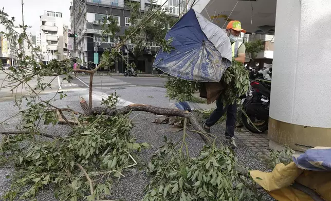 A sanitation worker of Kaohsiung city government clears debris in the aftermath of Typhoon Krathon in Kaohsiung, southern Taiwan, Friday, Oct. 4, 2024. (AP Photo/Chiang Ying-ying)