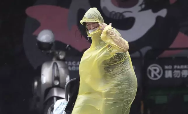 A woman struggles with winds generated by Typhoon Krathon in Kaohsiung, Southern Taiwan, Wednesday, Oct. 2, 2024. (AP Photo/Chiang Ying-ying)