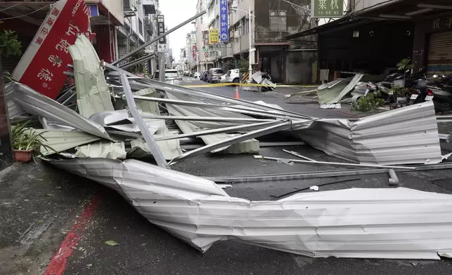 A blown roof destroyed by the wind of Typhoon Krathon, lay across a road in Kaohsiung, southern Taiwan, Friday, Oct. 4, 2024. (AP Photo/Chiang Ying-ying)