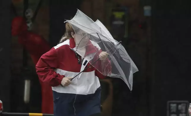 A woman struggles with winds generated by Typhoon Krathon in Kaohsiung, Southern Taiwan, Wednesday, Oct. 2, 2024. (AP Photo/Chiang Ying-ying)