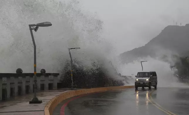 A car moves along the shore in Kaohsiung, southern Taiwan, Wednesday, Oct. 2, 2024, as Typhoon Krathon is expected to hit the area. (AP Photo/Chiang Ying-ying)