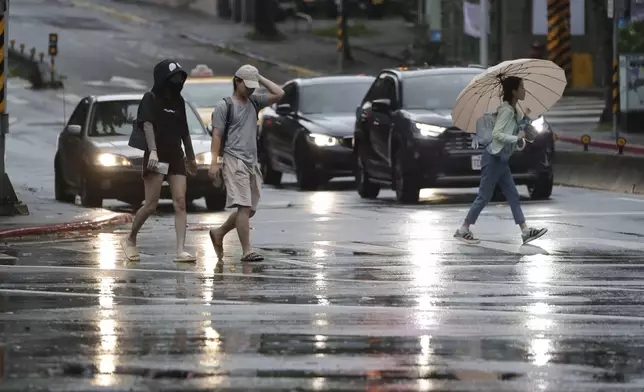 People walk in the rain as Typhoon Kong-rey approaches to Taiwan in Taipei, Taiwan, Thursday, Oct. 31, 2024. (AP Photo/Chiang Ying-ying)