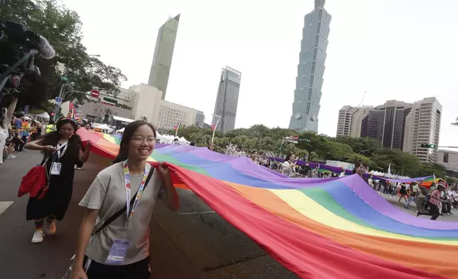 Participants revel through a street during the annual Taiwan LGBT Pride parade in Taipei, Taiwan, Saturday, Oct. 26, 2024. (AP Photo/Chiang Ying-ying)