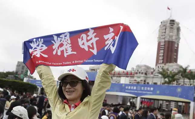 A person poses with a slogan reading "Honor Time" for a photo during National Day celebrations in front of the Presidential Building in Taipei, Taiwan, Thursday, Oct. 10, 2024. (AP Photo/Chiang Ying-ying)