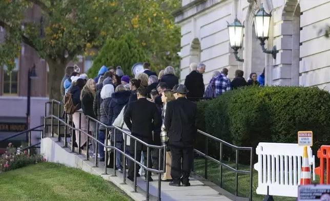 Spectators line up to enter the Carroll County Courthouse for the trail of Richard Allen, accused in the the 2017 slayings of two teenage girls, in Delphi, Ind., Friday, Oct. 18, 2024. (AP Photo/Michael Conroy)