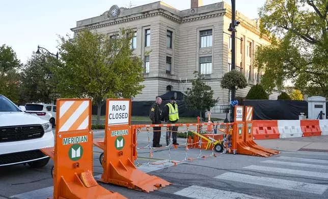 Security stand by a gate outside the Carroll County Courthouse where the trial of Richard Allen, accused of the slayings of two teenage girls in 2017, is set to begin in Delphi, Ind., Friday, Oct. 18, 2024. (AP Photo/Michael Conroy)