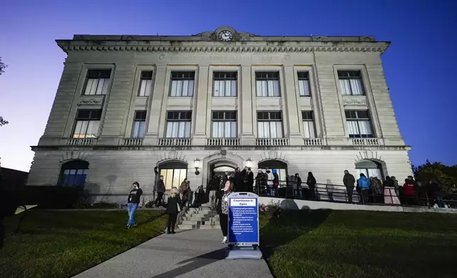 Spectators line up to enter the Carroll County Courthouse for the trail of Richard Allen, accused of the slayings of two teenage girls in 2017, is set to begin in Delphi, Ind., Friday, Oct. 18, 2024. (AP Photo/Michael Conroy)