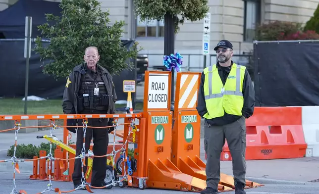 Security stands by a gate outside the Carroll County Courthouse where the trial of Richard Allen, accused of the slayings of two teenage girls in 2017, is set to begin in Delphi, Ind., Friday, Oct. 18, 2024. (AP Photo/Michael Conroy)