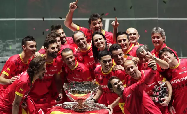 FILE - Spain's Rafael Nadal, foreground, takes a selfie with fellow players and team staff posing with the trophy after Spain defeated Canada 2-0 to win the Davis Cup final in Madrid, Spain, Sunday, Nov. 24, 2019. (AP Photo/Bernat Armangue, File)