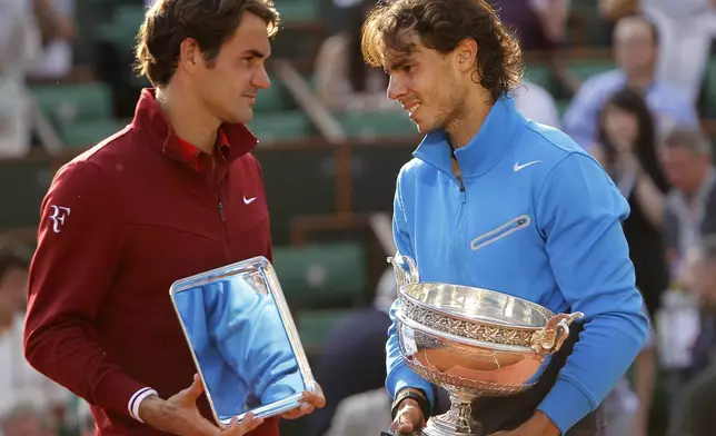 FILE - Spain's Rafael Nadal, right, and Switzerland's Roger Federer pose with their trophies after the men's final match for the French Open tennis tournament at Roland Garros stadium in Paris, June 5, 2011, as Nadal has announced he will retire from tennis at age 38 following the Davis Cup finals in November. (AP Photo/Lionel Cironneau, File)