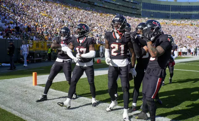 Teammates celebrate an interception by Houston Texans safety Calen Bullock (21) during the first half of an NFL football game against the Green Bay Packers, Sunday, Oct. 20, 2024, in Green Bay, Wis. (AP Photo/Morry Gash)