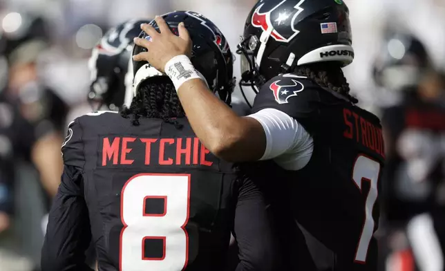 Houston Texans wide receiver John Metchie III (8) talks with quarterback C.J. Stroud (7) during warm-ups before an NFL football game against the Green Bay Packers, Sunday, Oct. 20, 2024, in Green Bay, Wis. (AP Photo/Matt Ludtke)