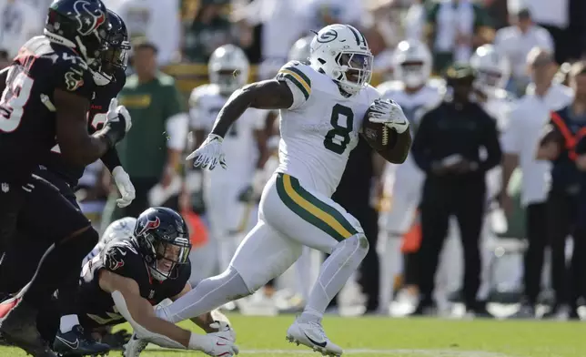 Green Bay Packers running back Josh Jacobs (8) rushes past Houston Texans linebacker Jake Hansen (35) for a first down during the second half of an NFL football game, Sunday, Oct. 20, 2024, in Green Bay, Wis. (AP Photo/Matt Ludtke)