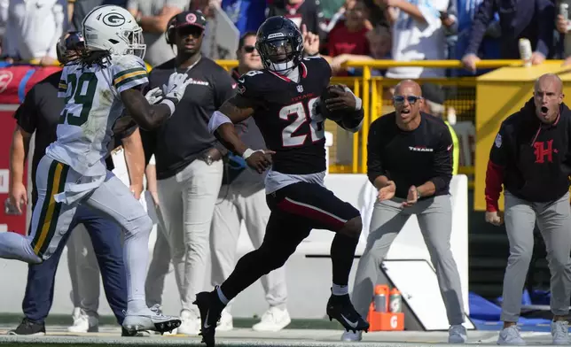 Houston Texans running back Joe Mixon (28) runs past Green Bay Packers safety Xavier McKinney (29) for a first down during the first half of an NFL football game, Sunday, Oct. 20, 2024, in Green Bay, Wis. (AP Photo/Morry Gash)