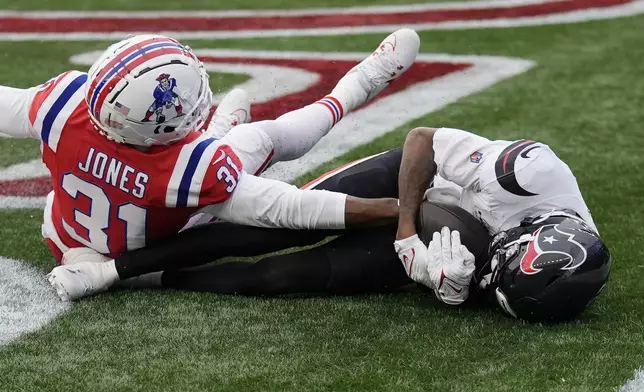 Houston Texans wide receiver Tank Dell holds onto his touchdown reception in the endzone against New England Patriots cornerback Jonathan Jones (31) during the first half of an NFL football game, Sunday, Oct. 13, 2024, in Foxborough, Mass. (AP Photo/Charles Krupa)