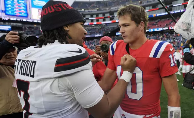 New England Patriots quarterback Drake Maye (10) and Houston Texans quarterback C.J. Stroud (7) meet on the field following an NFL football game, Sunday, Oct. 13, 2024, in Foxborough, Mass. (AP Photo/Charles Krupa)