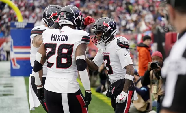 Houston Texans wide receiver Tank Dell (3) celebrates his touchdown with running back Joe Mixon (28) during the first half of an NFL football game against the New England Patriots, Sunday, Oct. 13, 2024, in Foxborough, Mass. (AP Photo/Charles Krupa)