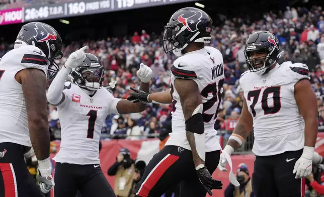 Houston Texans running back Joe Mixon (28) celebrates after his touchdown with wide receiver Stefon Diggs (1) and center Juice Scruggs (70) during the second half of an NFL football game against the New England Patriots, Sunday, Oct. 13, 2024, in Foxborough, Mass. (AP Photo/Steven Senne)