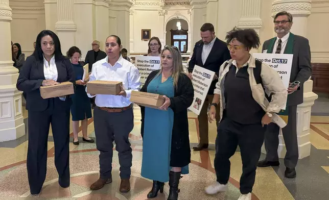 Casandra Rivera, left, Anna Vasquez, second from left, and Elizabeth Ramirez, center, of the "San Antonio 4" group, hold boxes with petitions being delivered in the Texas State capitol for Texas Gov. Greg Abbott seeking the pardoning of Robert Roberson's execution, Wednesday, Oct. 16, 2024 in Austin, Texas. Roberson, 57, is scheduled to receive a lethal injection on Oct. 17, for the 2002 killing of his 2-year-old daughter, Nikki Curtis, in the East Texas city of Palestine. Roberson has long proclaimed his innocence. (AP Photo/Nadia Lathan)