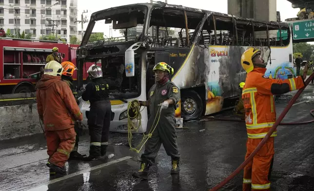 Rescuers work at the site of a bus that caught fire, carrying young students with their teachers, in suburban Bangkok, Tuesday, Oct. 1, 2024. (AP Photo/Sakchai Lalit)