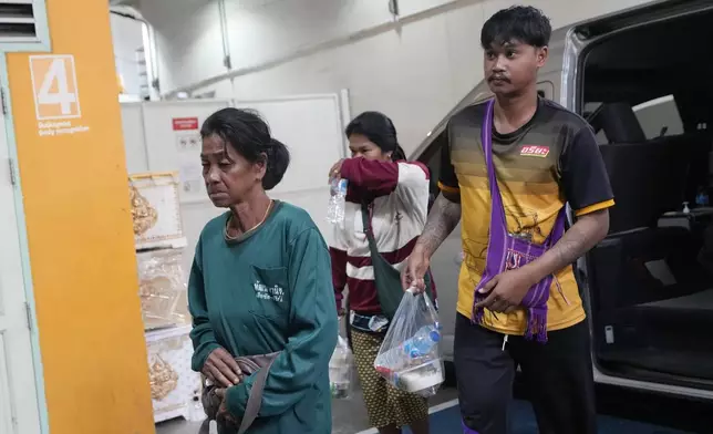 Family members of a victim arrive at a forensic police hospital in Bangkok, Thailand, Wednesday, Oct. 2, 2024, after a bus carrying students and teachers caught a fire Tuesday. (AP Photo/Sakchai Lalit)