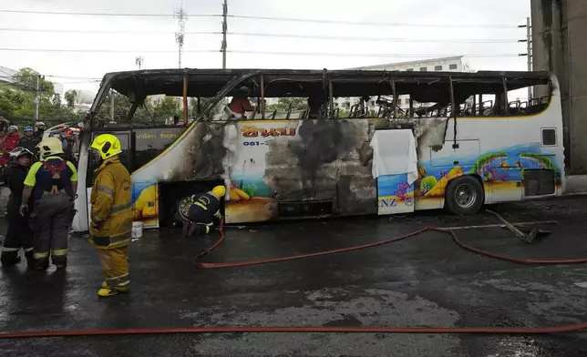 Rescuers work at the site of a bus that caught fire, carrying young students with their teachers, in suburban Bangkok, Tuesday, Oct. 1, 2024. (AP Photo/Sakchai Lalit)