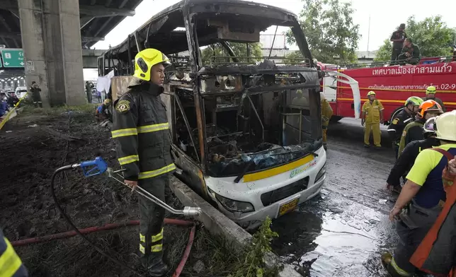 Rescuers work at the site of a bus that caught fire, carrying young students with their teachers, in suburban Bangkok, Tuesday, Oct. 1, 2024. (AP Photo/Sakchai Lalit)