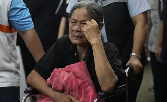 A grieving family member cries during the coffin procession for victims of a bus fire at Wat Khao Phraya Sangkharam School Lan Sak , Uthai Thani province, Thailand, Thursday, Oct. 3, 2024. AP Photo/Sakchai Lalit)