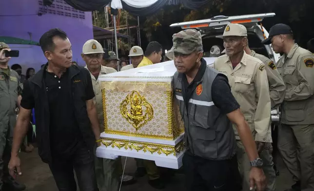 Officers carry a coffin of a bus fire victim as they arrive at Wat Khao Phraya Sangkharam School Lan Sak, Uthai Thani province, Thailand, Thursday, Oct. 3, 2024. (AP Photo/Sakchai Lalit)