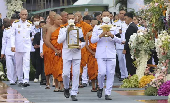 People arrive to offer their final respects at the cremation for victims of a school bus fire, at Wat Khao Phraya Sangkharam School, Lan Sak, Uthai Thani province, Thailand, Tuesday, Oct. 8, 2024. (AP Photo/Chatkla Samnaingjam)