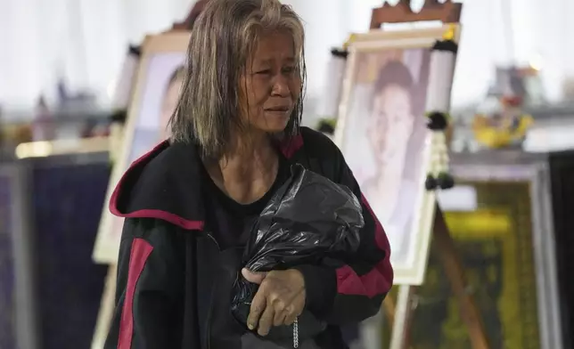 A relative of a victim of school bus fire cries at Wat Khao Phraya Sangkharam School, Lan Sak, Uthai Thani province, Thailand, Thursday, Oct. 3, 2024. (AP Photo/Sakchai Lalit)