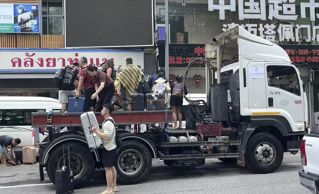 Tourists evacuate from a flood-hit area in Chiang Mai Province, Thailand, Saturday, Oct. 5, 2024. (AP Photo/Wichai Tapriew)