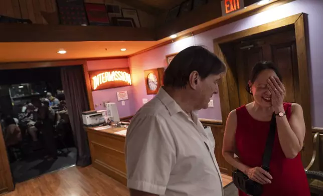 Matt, left, and Lesley Dzik, talk during intermission in the lobby of The Station Theatre while volunteering as ushers during a performance of "POTUS: Or, Behind Every Great Dumbass Are Seven Women Trying to Keep Him Alive," in Urbana, Ill., Saturday, Sept. 21, 2024. (AP Photo/David Goldman)