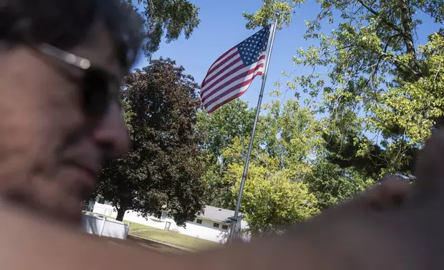 An American flag flies outside the home Matt Dzik shares with his wife, Lesley, in Champaign, Ill., Saturday, Sept. 21, 2024. "The country is flawed but it's a national symbol that transcends all our differences," said Matt. (AP Photo/David Goldman)