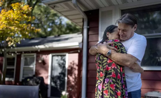 Matt Dzik, right, embraces his wife, Lesley, as he greets her after waking up in Champaign, Ill., Saturday, Sept. 21, 2024. Their need for one another is too great to avoid the discomforts of their many disagreements. "We share the same heart," said Lesley. "I love looking in her eyes and seeing her smile," said Matt. "Why would I want to lose that? (AP Photo/David Goldman)